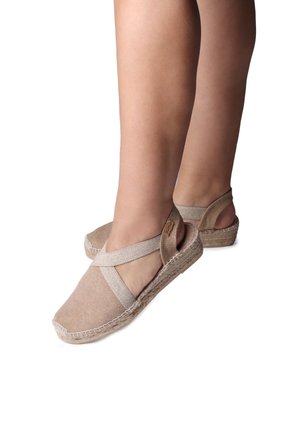 Beige espadrille sandals made of soft fabric with cross straps and a braided jute sole. Features a low wedge for comfort.