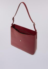 Borsa a tracolla in pelle rossa con una sola cinghia, texture liscia, tasche interne con cerniera e aperte, caratterizzata da un piccolo logo argento sul davanti.