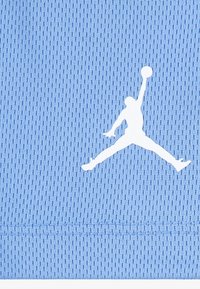 Ljusblå nätväv med en framträdande vit Jumpman-silhuett, med en texturerad yta och prydlig fåll.