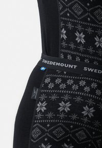 Svarta termoleggings med ett geometriskt snöflinge-mönster i grått, med en SWEDEMOUNT midjeband och logotypetikett.