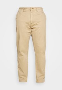 Beiga chinos i bomull med rak bendesign, med knappstängning fram och sidofickor. Slät textur med minimal detaljer.