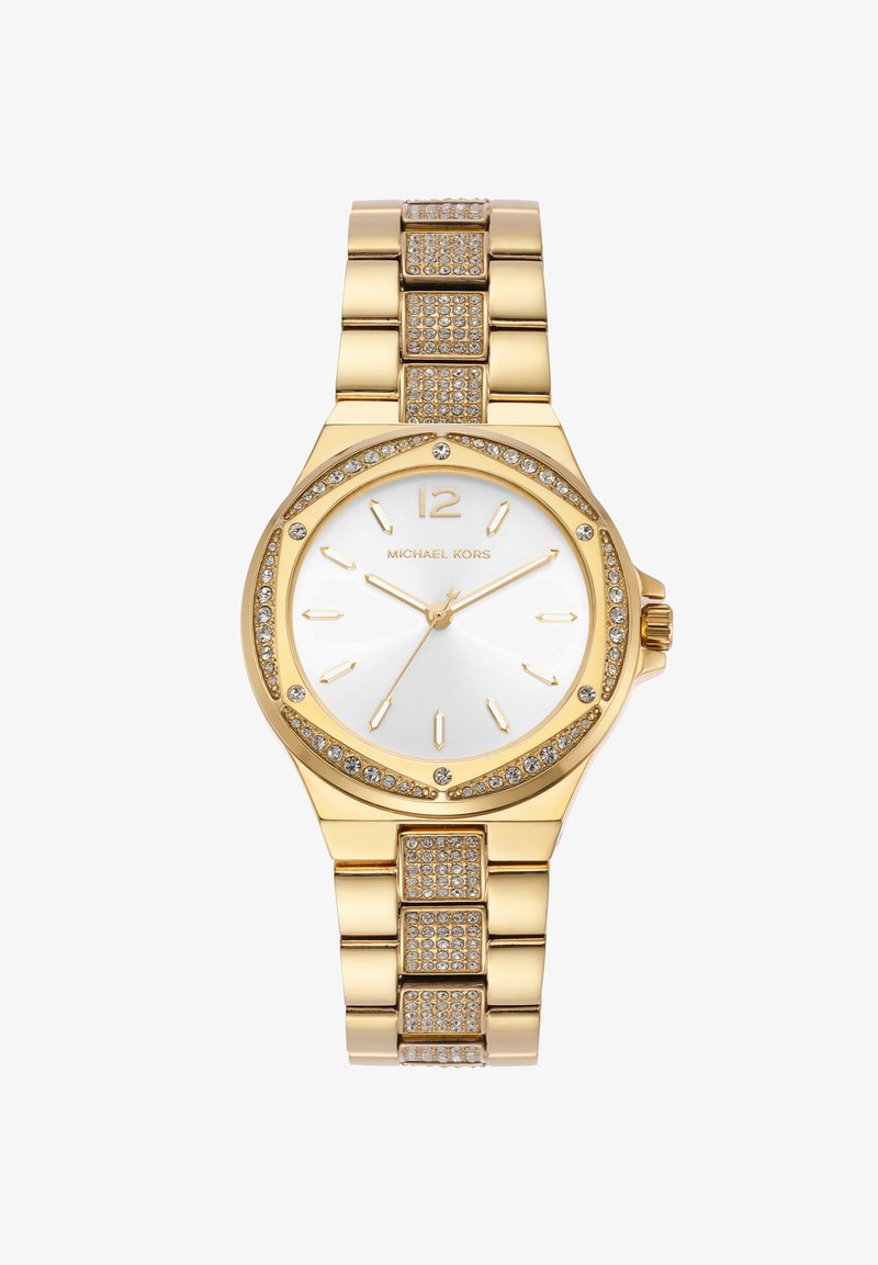 Zelta tonis pulksteņi ar apaļu seju, baltu ciparnīcu, zelta atzīmēm un gredzenu, kas ietverts ar kristāliem. Savienojuma rokassprādze ar teksturētiem akcentiem.