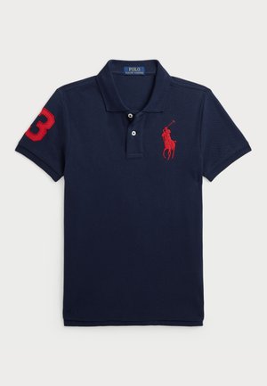 Marineblå poloshirt med rødt polospiller-logo på brystet, rød nummer 3-patch på ærmet, korte ærmer og krave med to knapper.