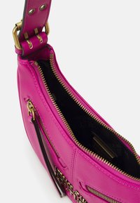 Fuchsia leather handbag with gold hardware, zip closure, and black interior. Features exterior pockets and logo accents.