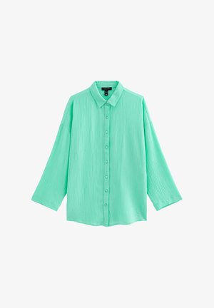 Chemise boutonnée vert menthe à manches longues froissée avec col classique et coupe décontractée, présentée sur un fond blanc.