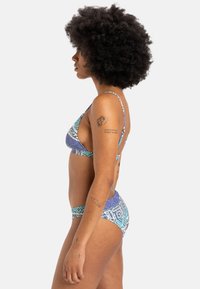 Bikini set with a geometric pattern in blue, purple, and turquoise. Features thin straps and a triangular top design. Smooth texture.