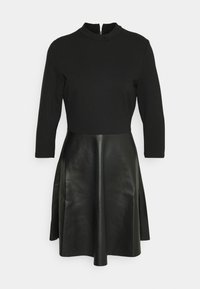 Robe noire avec manches trois-quarts, col montant et jupe évasée en simili cuir.