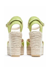 Sandales à plateforme en suede vert avec un talon compensé en jute, dotées d'une bride de cheville réglable et d'un design à talon découpé.