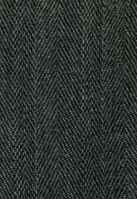 Black herringbone fabric showcasing a textured pattern with diagonal lines. Material is dense with visible fibers, creating a structured appearance.