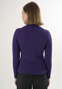 Lila gestrickter Pullover mit einem Zopfmuster, langen Ärmeln, schmalen Taillen und gerippten Bündchen. Das Design ist strukturiert und körperbetont.