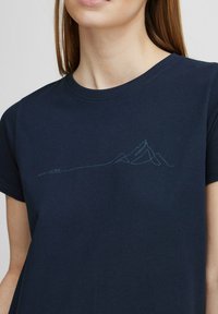 Camiseta de algodón azul marino con un dibujo lineal minimalista de montañas en el frente, con una textura suave y un clásico cuello redondo.