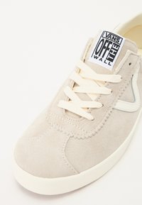 Svijetlosivi nubuk startas s kremastim vezicama, s bijelim gumenim potplatom i Vans "Off the Wall" logotipom na jeziku.