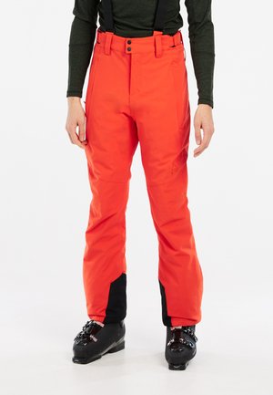 Pantalones de esquí naranja brillante con tirantes negros ajustables, un ajuste ajustado, acentos negros en las piernas y cierre de botón en la cintura.