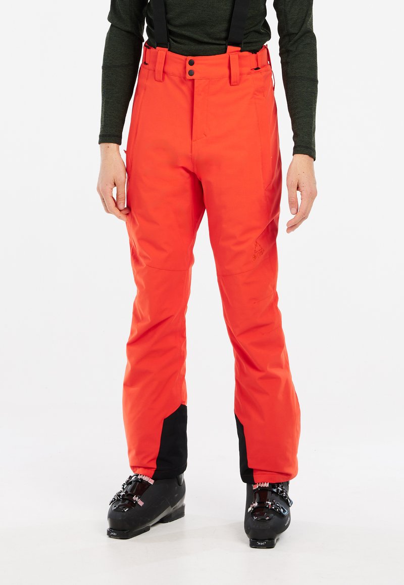Pantalons de ski orange vif avec bretelles noires réglables, une coupe ajustée, des accents noirs au niveau des jambes et une fermeture à bouton à la taille.