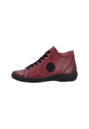Baskets montantes en cuir rouge avec lacets noirs, semelle en caoutchouc, détail de logo circulaire, et accents noirs contrastants.