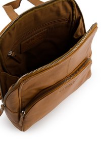 Sac à dos en cuir marron avec deux poches zippées, une surface texturée et un intérieur doublé en tissu. Présente une étiquette nommée à l'intérieur.