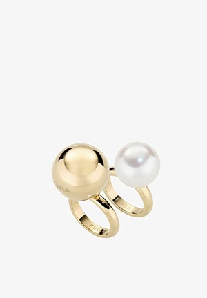 Bague double en or et blanc présentant deux éléments sphériques, l'un en or réfléchissant, l'autre une perle blanche brillante, avec une gravure de la marque.