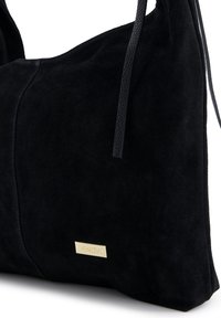Czarna torebka z zamszu o gładkiej fakturze, z zaokrąglonym kształtem, długimi czarnymi uchwytami i małym złotym logo.