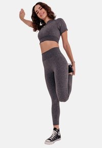 Gray activewear set featuring a short-sleeve crop top and high-waisted leggings, paired with black high-top sneakers. Smooth texture, athletic fit.