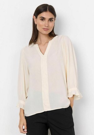 Helle Cremefarbene Bluse aus transparenter Stoff, mit V-Ausschnitt, Dreiviertelärmeln mit Rüschensaum und einem schmalen vertikalen Vorderteil.