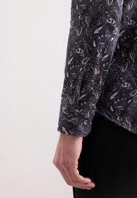 Camicia a maniche lunghe in tessuto scuro con motivo paisley; presenta bottoni ai polsini, texture liscia e taglio aderente.