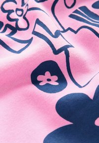 Bomullstyg i rosa med mörkblå blommönster och abstrakta former; slät textur med en något sträckt utseende.