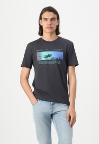 Svart bomull T-skjorte med grafisk trykk i blå og grønne nyanser. Designet inkluderer tekst og palmer, med rund hals og korte ermer.