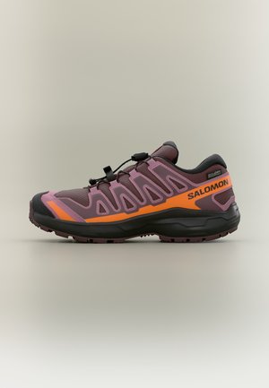 Trailrunning-Schuh in Lila und Orange mit schwarzer Sohle, Schnell-Schnürsystem und Salomon-Logo auf der seitlichen Lasche.