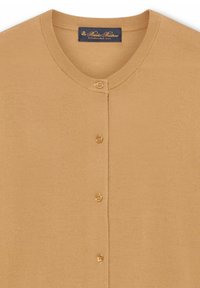 Beżowy kardigan zapinany na guziki z okrągłym dekoltem i prążkowanym kołnierzem, z metką Brooks Brothers wewnątrz przy szyi.