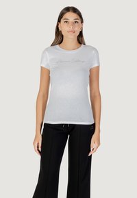 Witte, aansluitende T-shirt gemaakt van een gladde stof, met een subtiele 'Armani Exchange' logo in een script op de voorkant. Korte mouwen en een ronde hals.