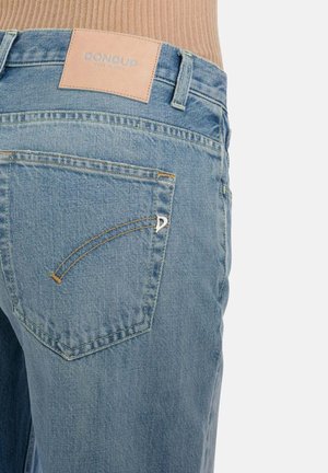 Lichtblauwe spijkerbroek met stiksel op de achterzak en een lichtbruine leren merklabel met de tekst "DondUP Made in Italy."