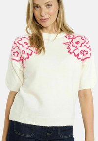 Maglione bianco lavorato a maglia con maniche corte e puffate. Presenta vivaci motivi floreali rosa sulle spalle. Texture morbida e vestibilità casual.
