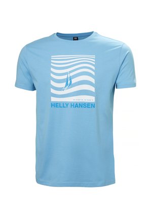 Jasnoniebieska koszulka bawełniana z białą grafiką fal i żaglówki. Pod nią znajduje się tekst "HELly HANSEN" napisany pogrubionymi niebieskimi literami.
