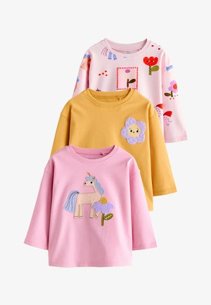 Drei Kinderlangarmshirts: rosa mit Einhorn und Blume, gelb mit lächelndem Blumenaufnäher und hellrosa mit bunten Blumenmustern.