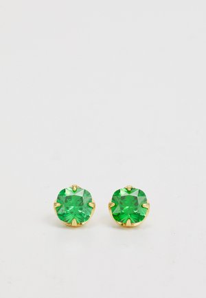 Orecchini a forma di pietra verde tonda incastonati in oro, con impostazioni a griffe. Le pietre hanno una superficie sfaccettata che riflette la luce, senza ulteriori abbellimenti.