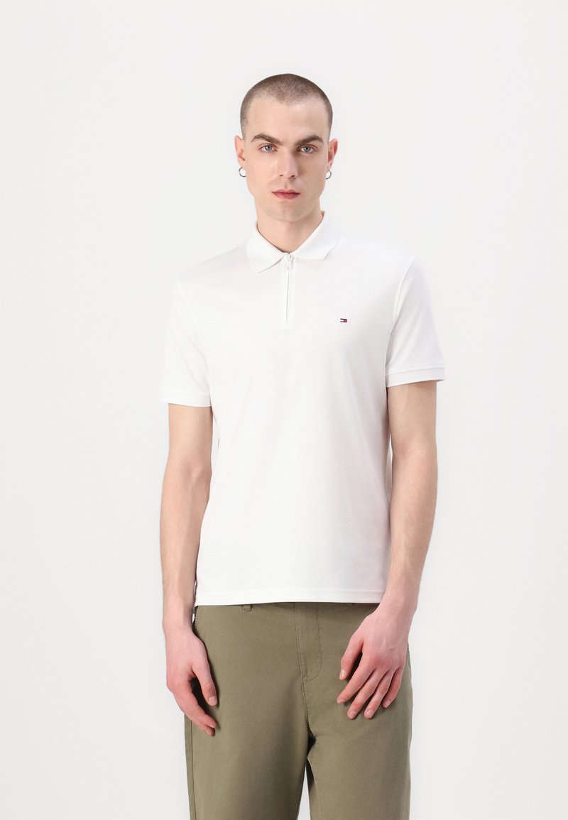 Witte poloshirt met een ritskraag, gemaakt van gladde katoen. Heeft korte mouwen en een klein logo op de linkerborst. Casual fit.
