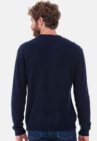 Pull en maille bleu marine avec un col rond, des poignets et un ourlet côtelés, doté d'un tissu doux et texturé ainsi qu'une coupe décontractée.