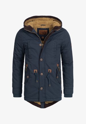 Parka bleu marine avec une capuche doublée de fourrure, deux poches avant et des accents en cuir marron. Fermeture par bouton et zip avec des poignets côtelés.