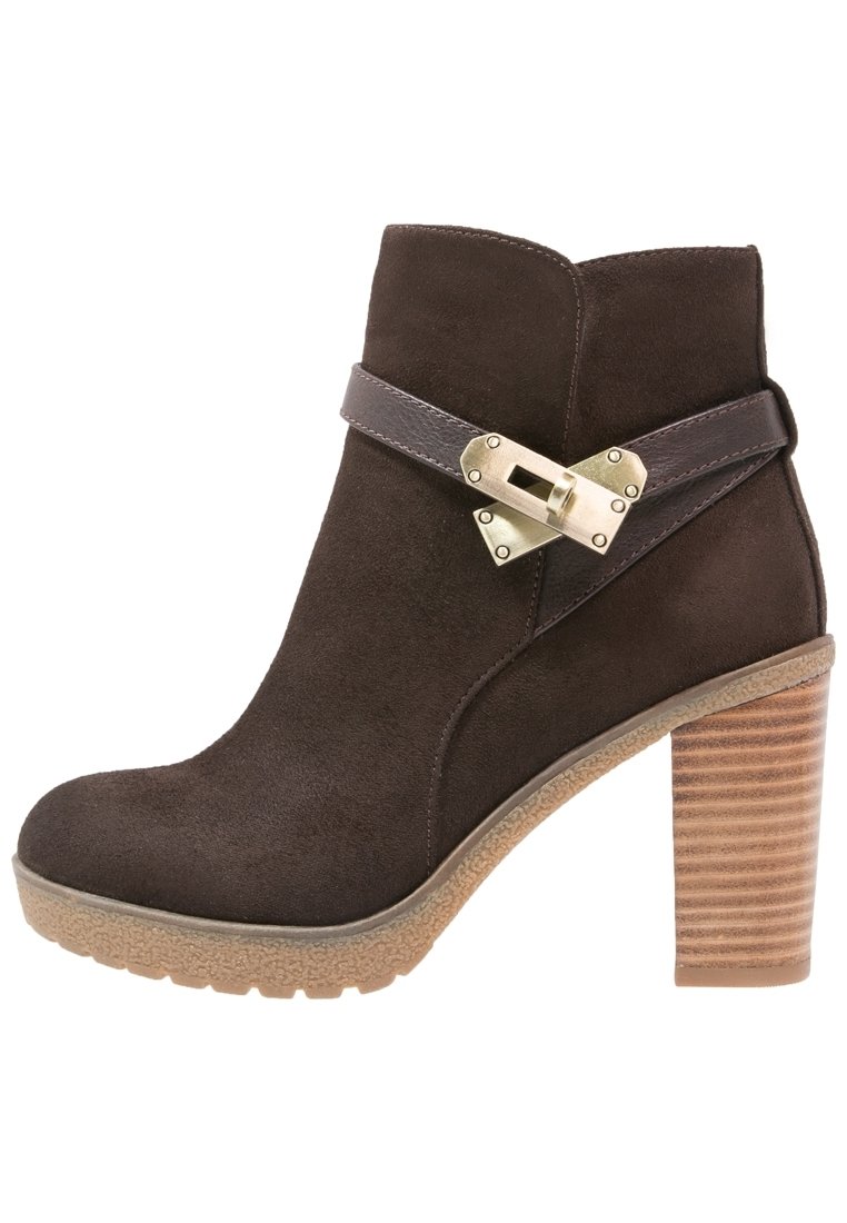 Bruna mocka ankelboots med rund tå, ett mörkt band med en metallspänne och en texturerad, staplad klack. Gummisula för bra grepp.