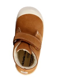 Scarpa di camoscio marrone con fascia in velcro, punta in gomma bianca e fodera morbida. Logo del produttore visibile all'interno.