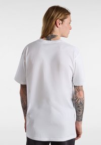 Bílý bavlněný tričko s krátkým rukávem, kulatým výstřihem a volným střihem. Má hladkou texturu a minimalistický design bez ozdob.