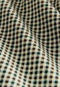Tessuto intrecciato con un motivo a pied-de-poule nei colori crema, marrone e verde. Morbida consistenza con fili visibili e una leggera lucentezza.