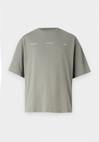 Prevelik kratkosleeven t-shirt v olivno zeleni bombažni tkanini. Ima belo in zlat napis spredaj, okroglo izrezan ovratnik in sproščen kroj.