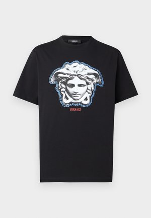 Sort bomulds-T-shirt med en markant Medusa-hovedgrafik i grå og blå med et græsk nøgledesign og teksten "VERSACE" i rødt.