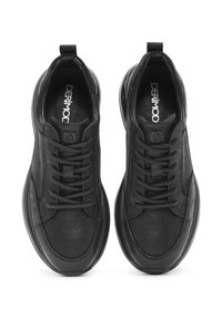 Zapatillas negras con cordones que presentan un upper de cuero texturizado, punta redondeada y una suela gruesa y suave para mayor amortiguación y soporte.