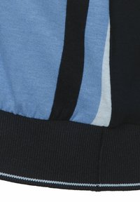 Gestreifter blauer Stoff mit dunklen, hellen und blassen blauen Paneelen, ergänzt durch einen gerippten schwarzen Bund und kontrastierende Nähte.