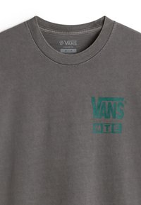 Grå løs siddende t-shirt lavet af bomuld, med et turkist Vans-logo trykt på brystet. Klassisk crew neck design.