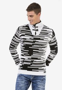 Schwarz-weiß gestreifter Strickpullover mit hohem Kragen und Knöpfen, strukturiertem Rippenstoff und kontrastierenden horizontalen Linien.