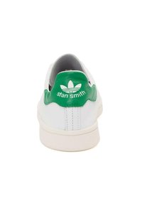 Bílé kožené tenisky s zelenou patou s textem "stan smith" a logem se třemi listy. Hladký povrch, gumová podrážka. Pohled zezadu.