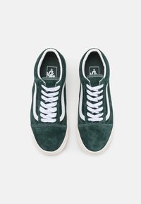 Baskets en daim vert avec lacets blancs et bande latérale contrastante. Présentent une finition texturée et une semelle en caoutchouc pour une meilleure adhérence.